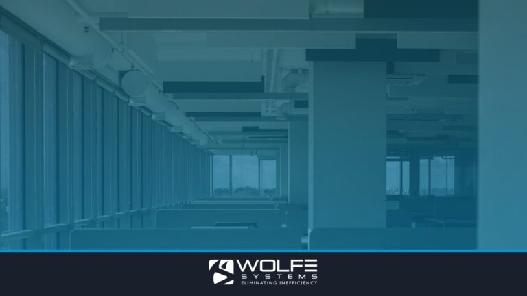 Spacious empty office with rows of desks and large windows.