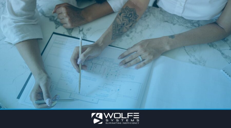 Two women collaborating on architectural blueprints, emphasizing teamwork and design.