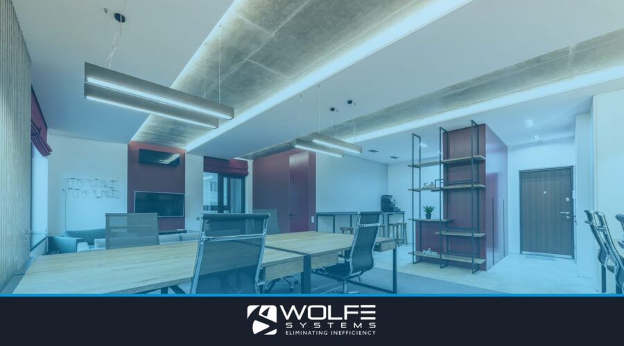 Interior of modern workplace with wooden tables and chairs under lamps next to shelves and door