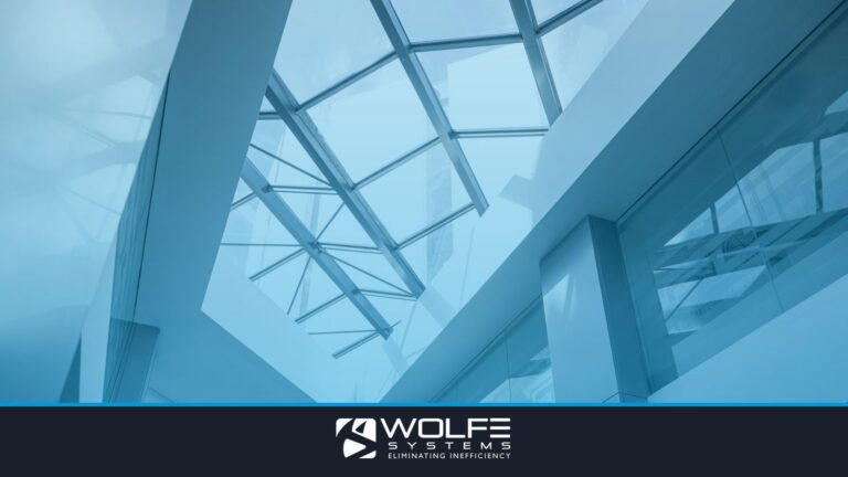 An interior look at a modern office building featuring a glass ceiling and sleek steel frames.