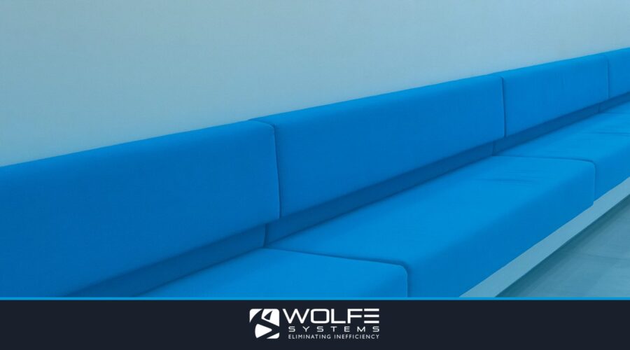 Long blue minimalist sofa seating against a white wall in a modern room.