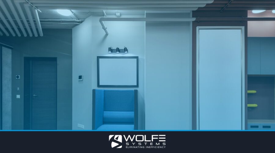 Interior of modern spacious hallway with blue armchair and entrance door leading into workplace