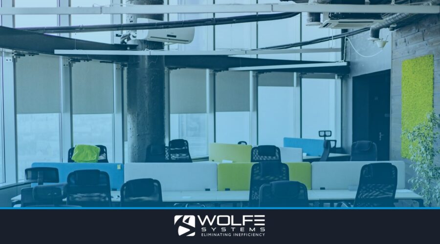 Bright and spacious open office with colorful partitioned desks and natural light.